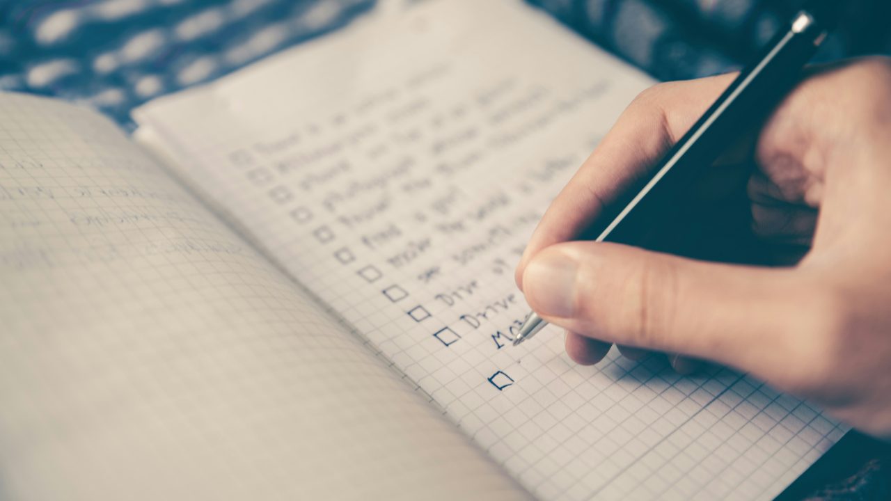 close up of persons hand making a list