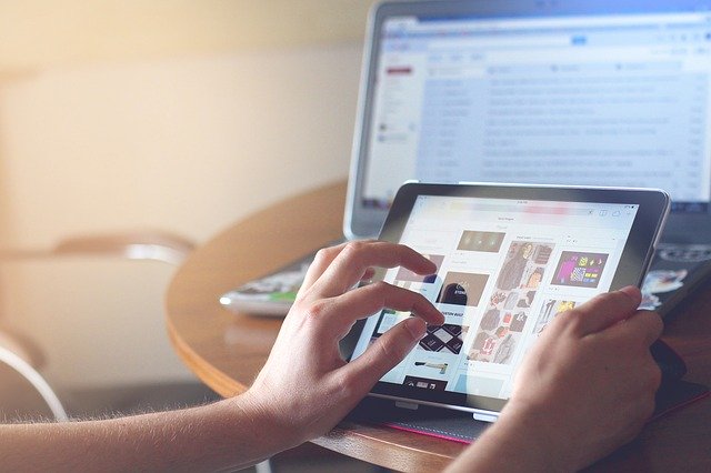person using ipad over their computer