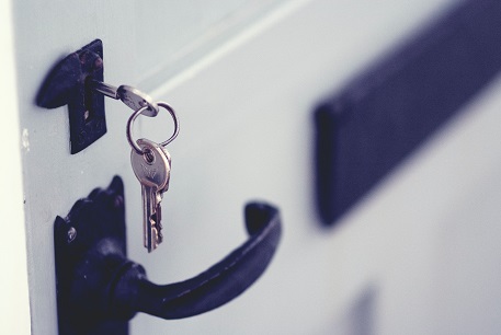 keys in lock above unopened door.