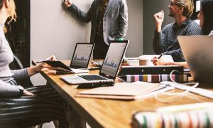 business owner white boarding with employees