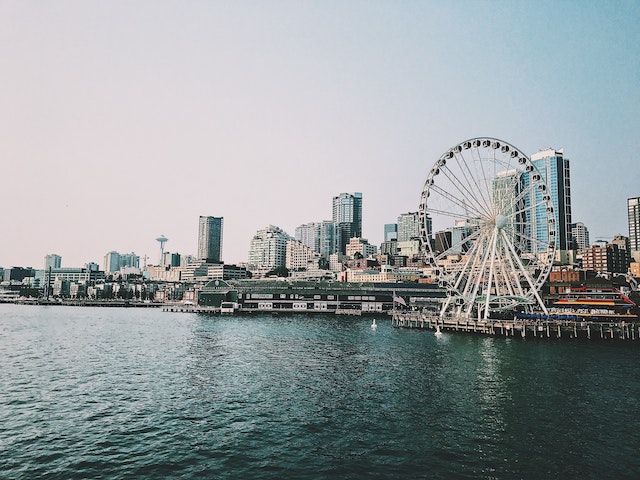 Landscape shot of the Puget Sound with the space needle off to the left and the Ferris wheel on the pier on the right