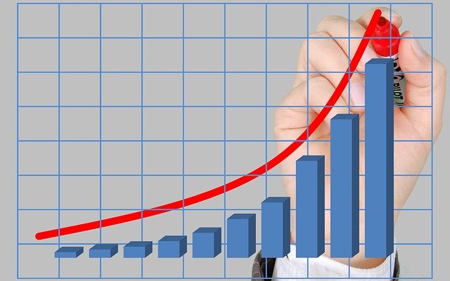 a hand drawing a red line along the curve of a bar graph