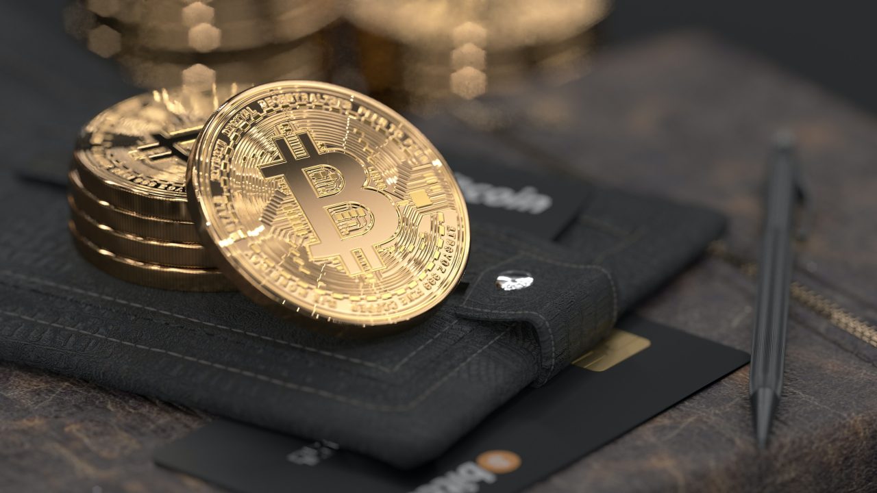 a stack of bitcoins on a black wallet