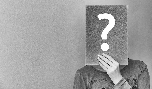 a woman holding a question mark in front of her face