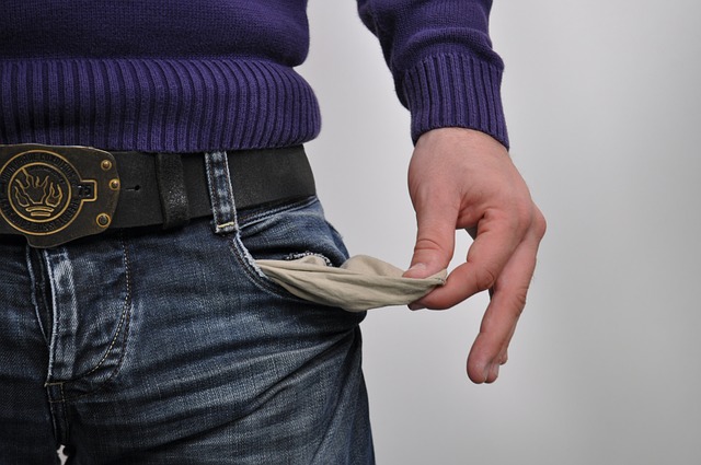 man turning his pocket inside out to show its empty