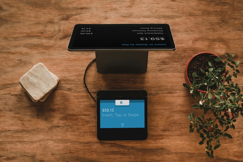top-down view of ipad with a square payment system on a desk
