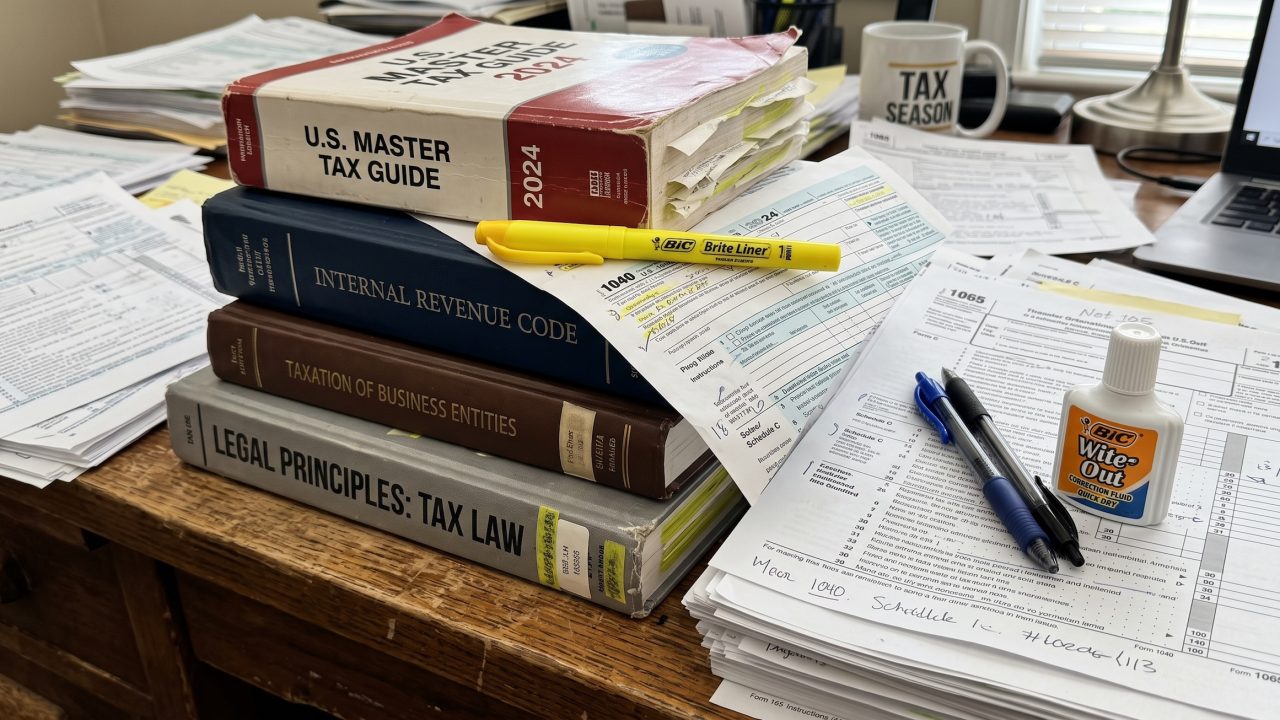 tax forms and books stacked on a desk